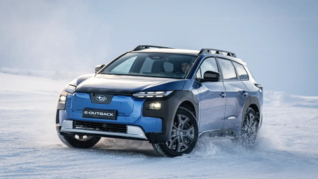 Blå Subaru E-Outback kjører i snø med to personer inni.