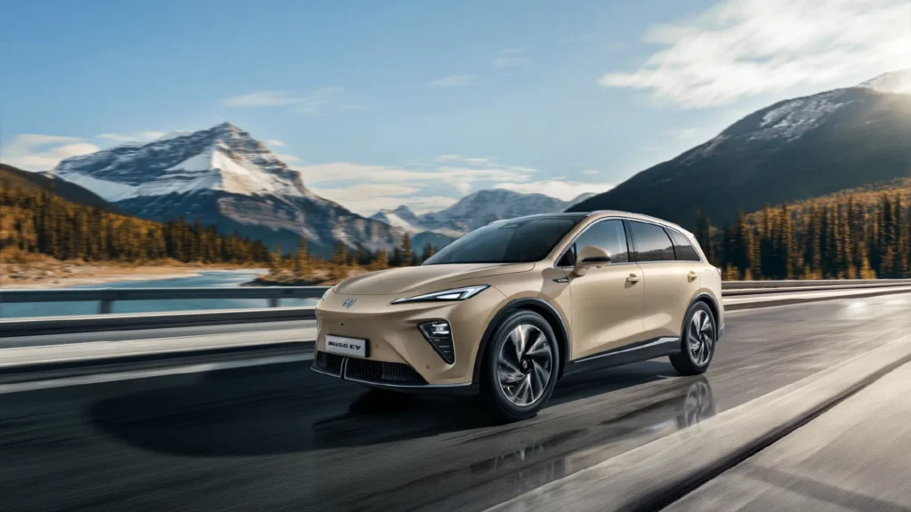 SUV kjører på vei ved innsjø og snødekte fjell.