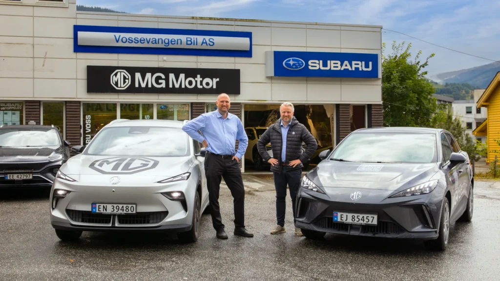 To menn står ved MG-bilene foran bilforhandleren.